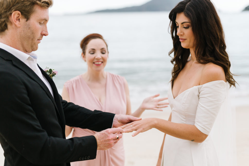 Celebrant Julie Muir getting the couple to exchange rings during Shoal Bay Beach Elopement 