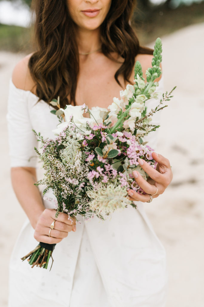 Bride holding simple flowers for her Shoal Bay Beach Elopement 