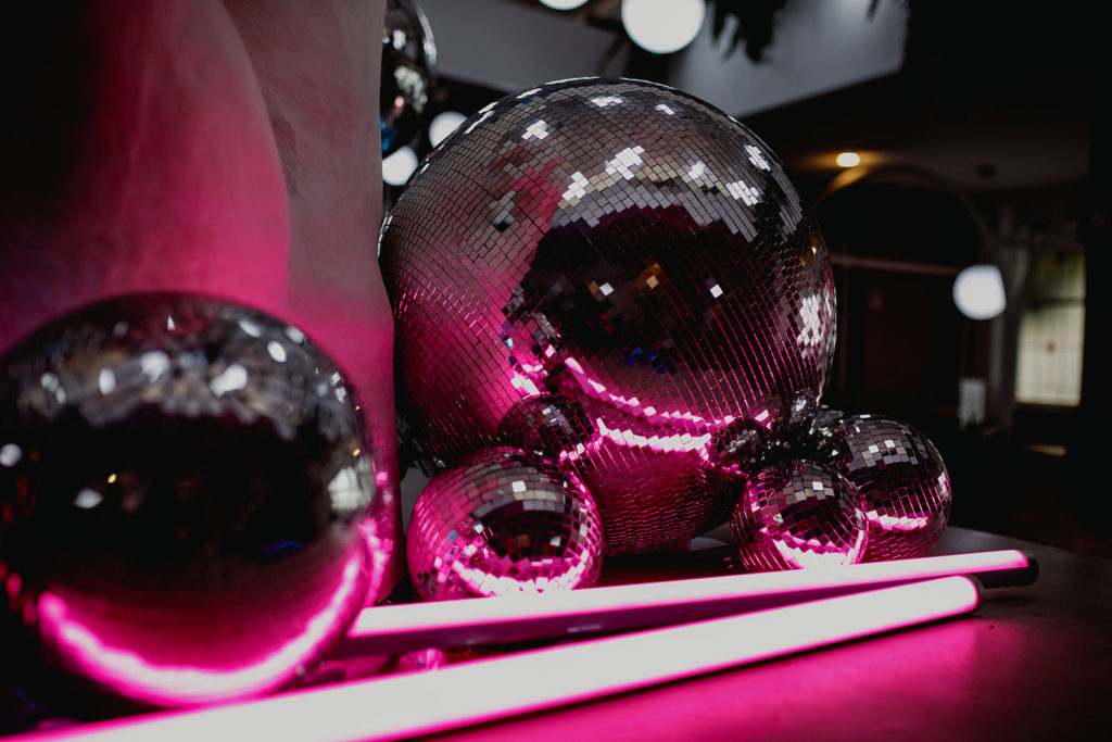 Disco balls with pink neon lights for this disco inspired wedding shoot