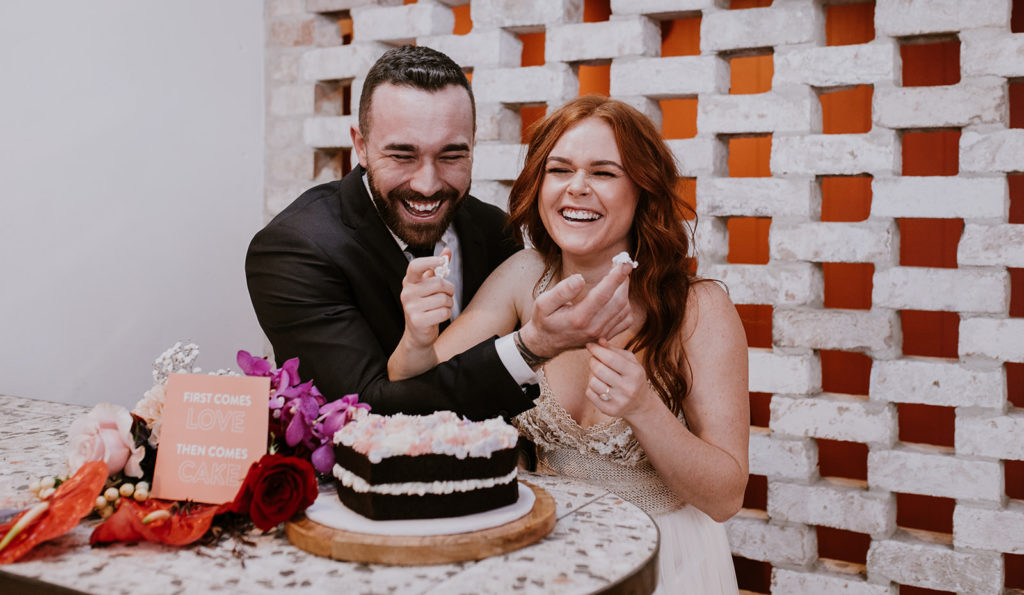 Couple eating cake at disco inspired wedding