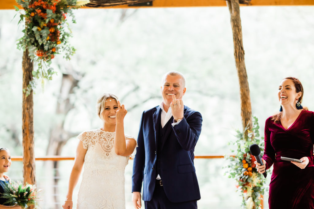 Hunter Valley Wedding Venue Stonehurst Cedar Creek newlyweds showing off their wedding rings beside Celebrant Julie Muir