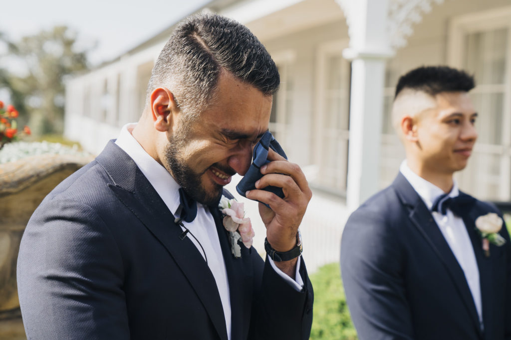 Groom holds navy handkerchief to face cry during your wedding