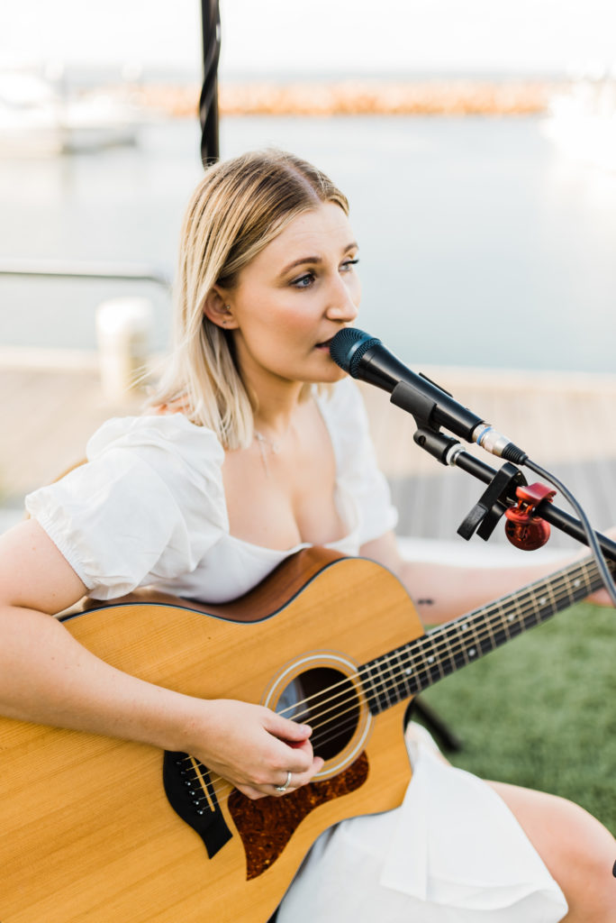 The Anchorage wedding musician singing while playing her acoustic guitar