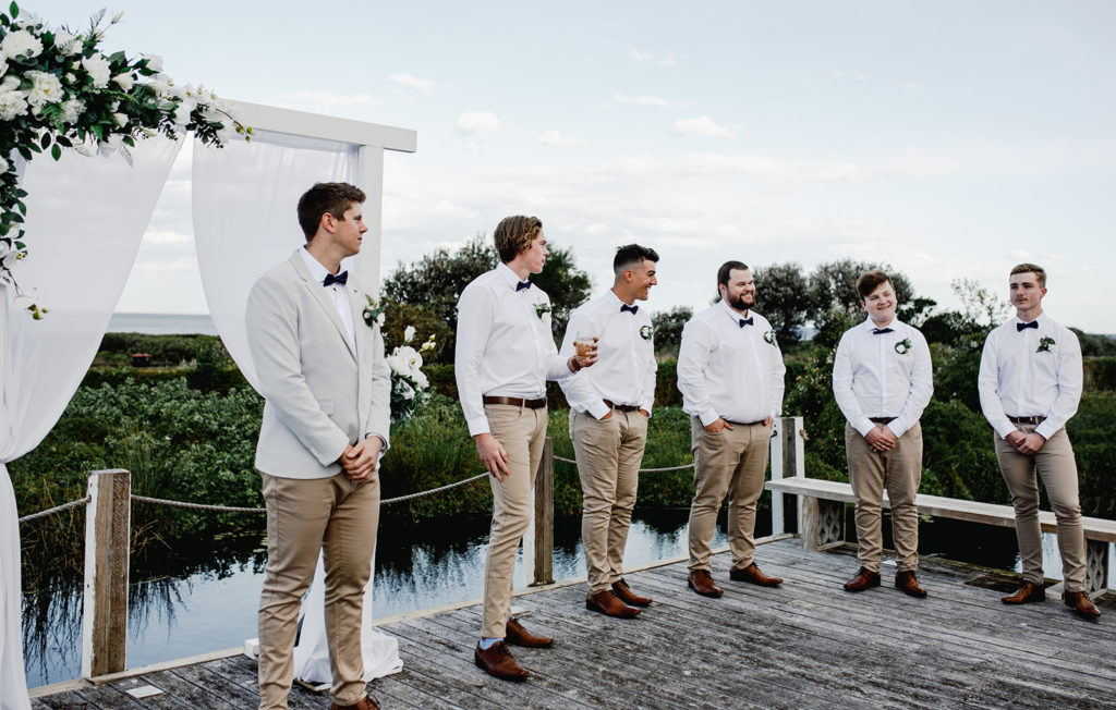Groom and groomsmen stand ready at Caves Coastal Bar & Bungalows