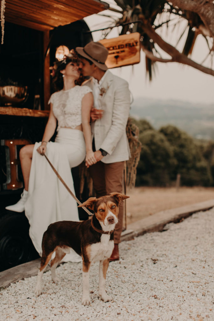 boho wedding inspiration couple in front of mobile bar with dog