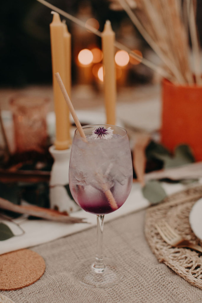 boho wedding inspiration purple cocktail with dried flower and straw