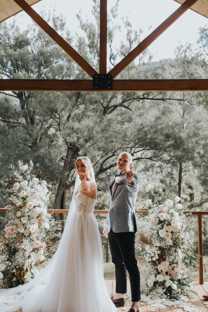 Couple outstretch ring fingers at Stonehurst Cedar Creek Micro Wedding