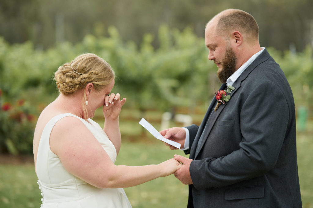 bride crying while groom is reading his vow