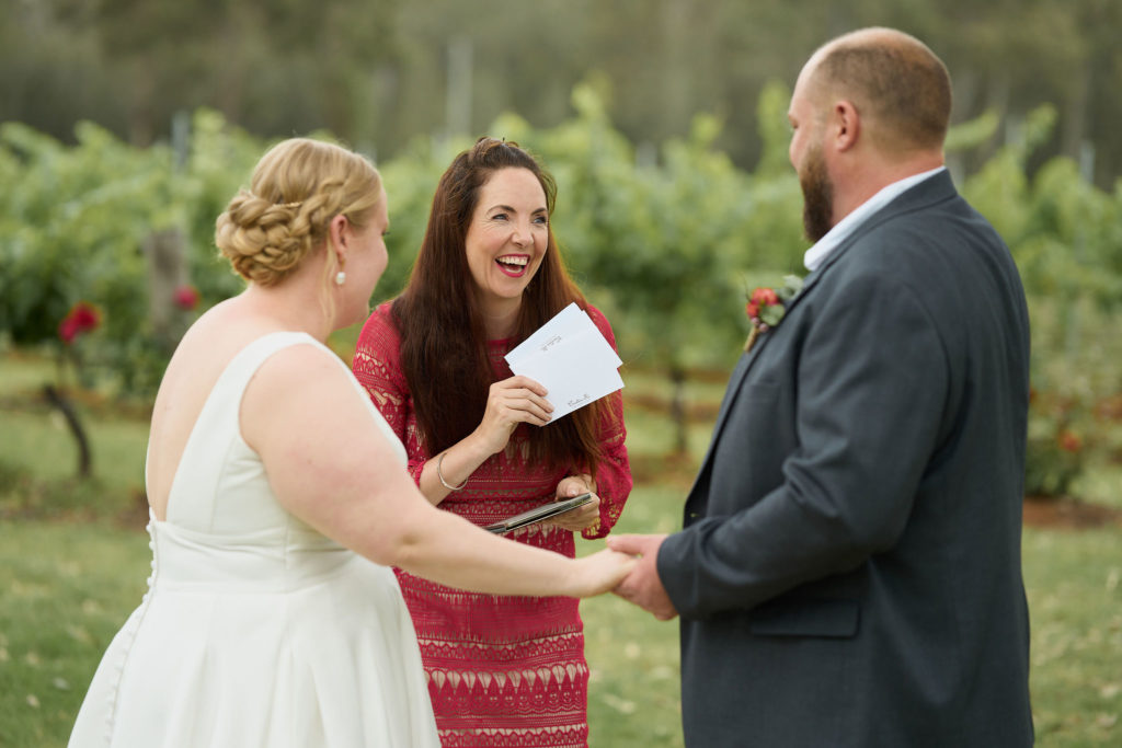 Celebrant Julie Muir laughing with the bride and groom at their wedding at Spicers Vineyard Estate