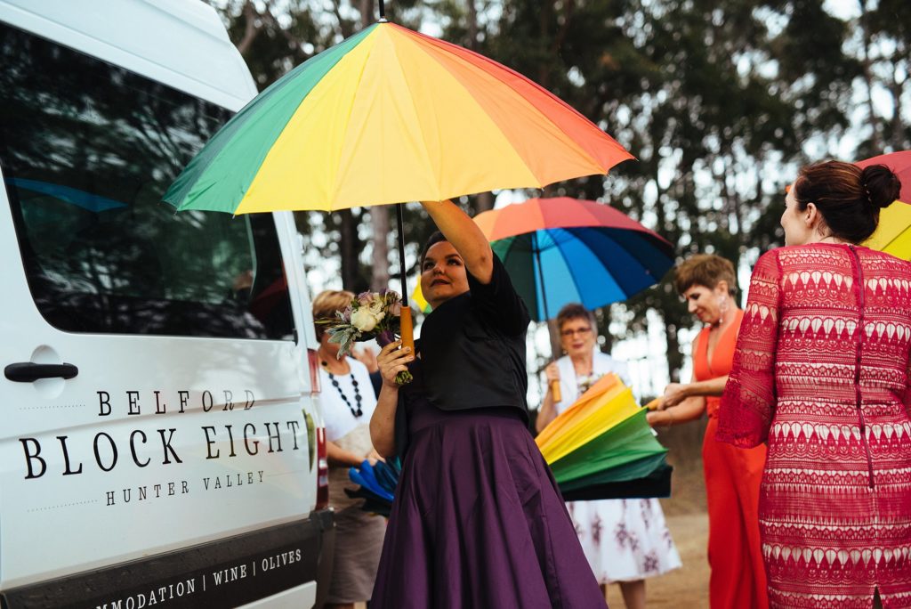 Bride opening a rainbow umbrella at Block Eight Winery wedding