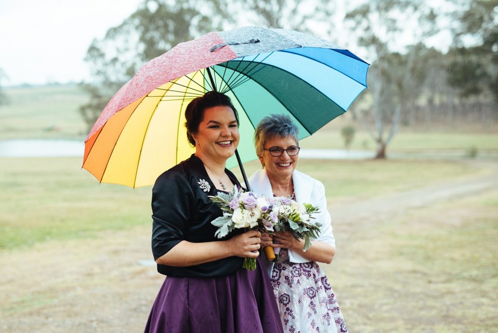 Block Eight Winery wedding couple sharing a rainbow umbrella