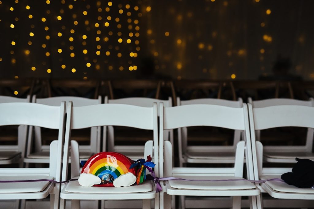 A rainbow bag sitting on one of the white chairs at Block Eight Winery wedding venue
