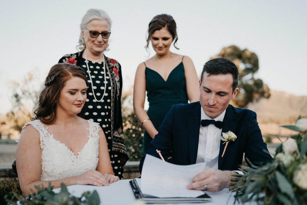 Newlyweds signing their marriage certificate at Margan Winery wedding