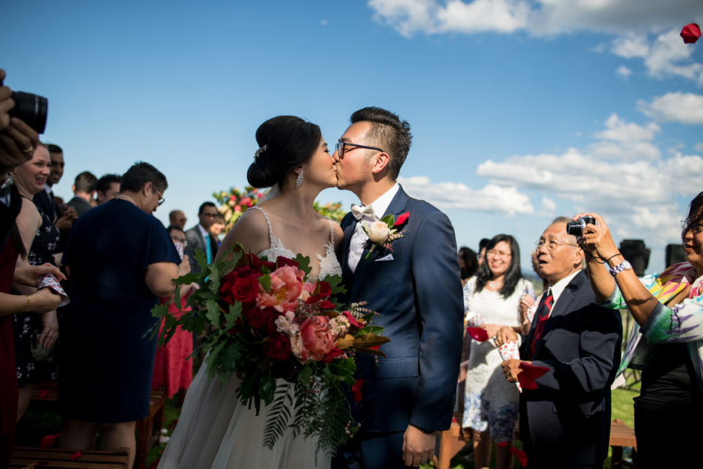 Newlyweds sharing a kiss within the crowd of guests at Ben Ean Winery wedding