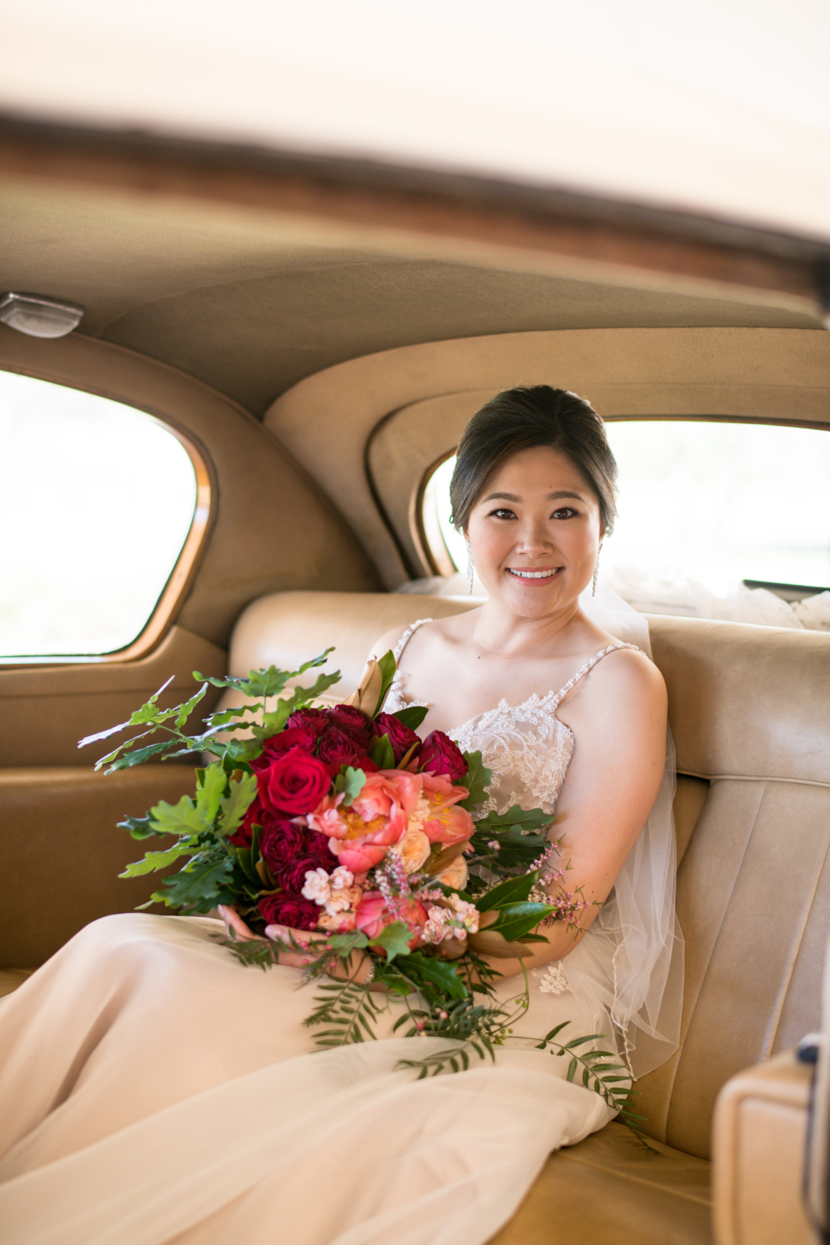 Bride smiling and holding her bouquet while waiting in the car at Ben Ean Winery wedding