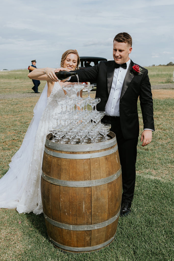 Hunter Valley Wedding Venue Bimbadgen Palmers Lane bride and groom pouring wine on wine glass tower