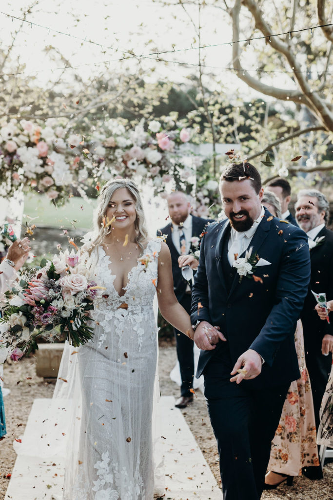 Bride and groom showered with petals while walking down the aisle at Fernbank Farm