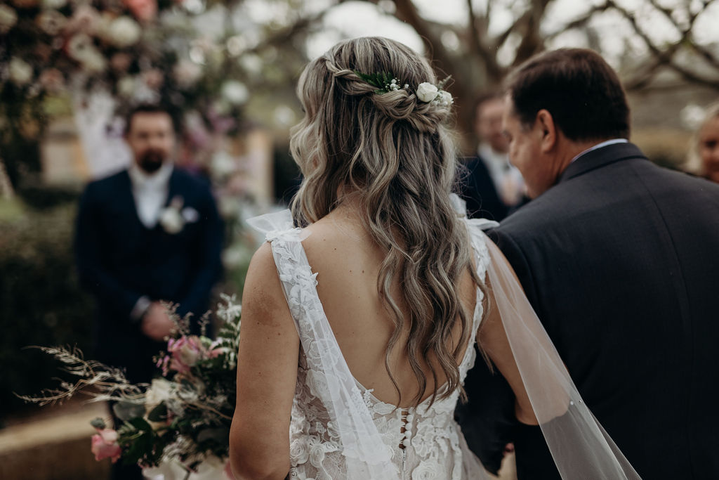 view of bride showing her long wavy hair and details of her dress from behind