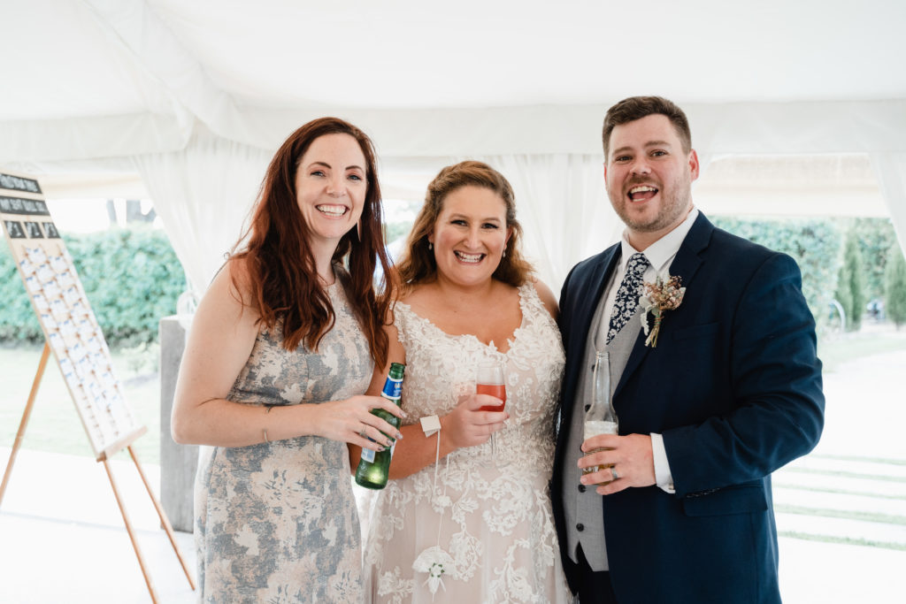 Celebrant Julie Muir and newlyweds with alcoholic drinks in their hands at Wallalong House