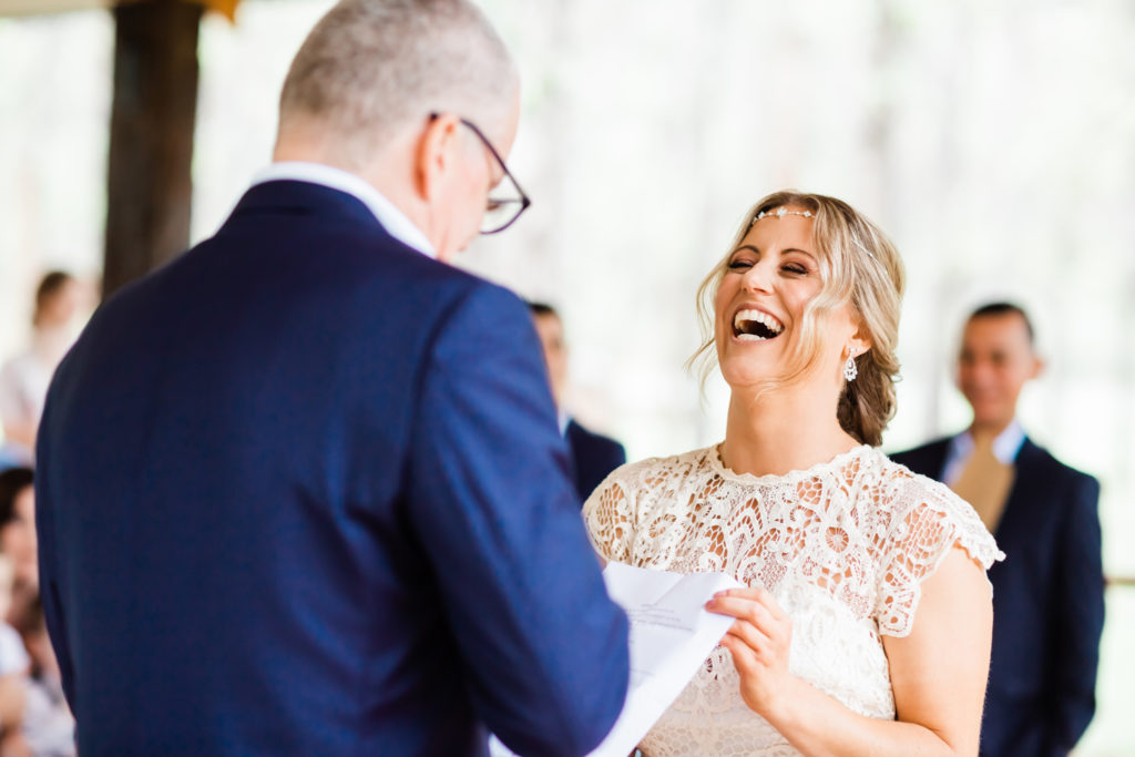 Bride throwing her head back laughter at Stonehurst Cedar Creek Wedding