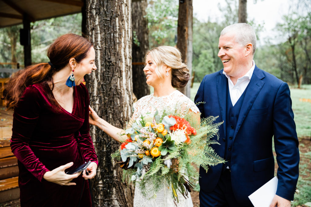 Celebrant Julie Muir laughing with newlyweds after their ceremony at Stonehurst Cedar Creek wedding