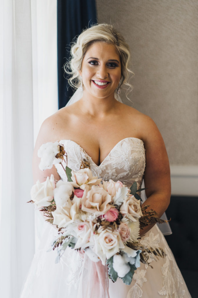 Voco Kirkton Park bride smiling while holding her bouquet