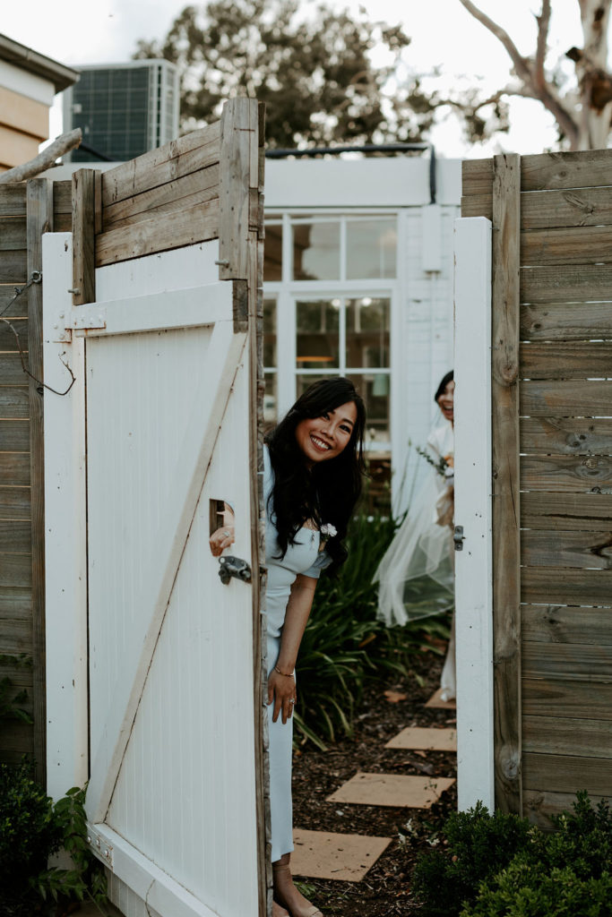 Maid of honor peeking from an open wooden door at Vinden Wines