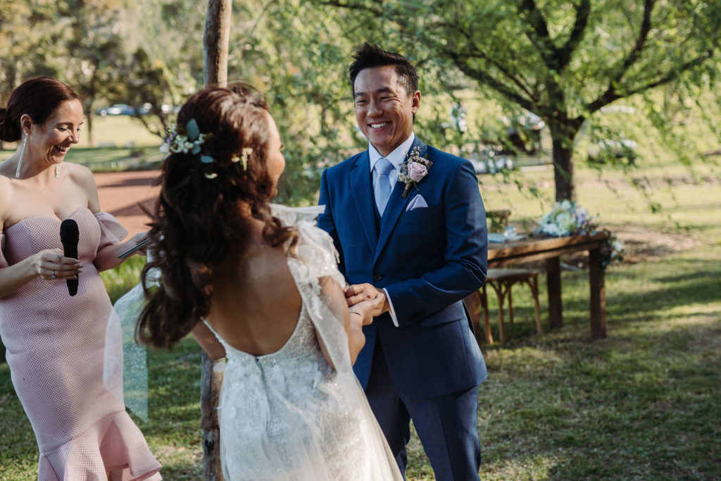 Couple holding hands and laughing mid wedding at The Woodhouse Wollombi