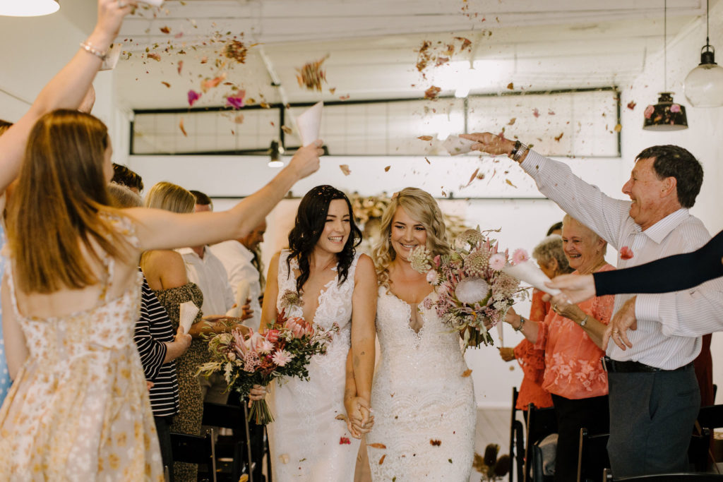 The Wedding Social Co with brides showered in petals