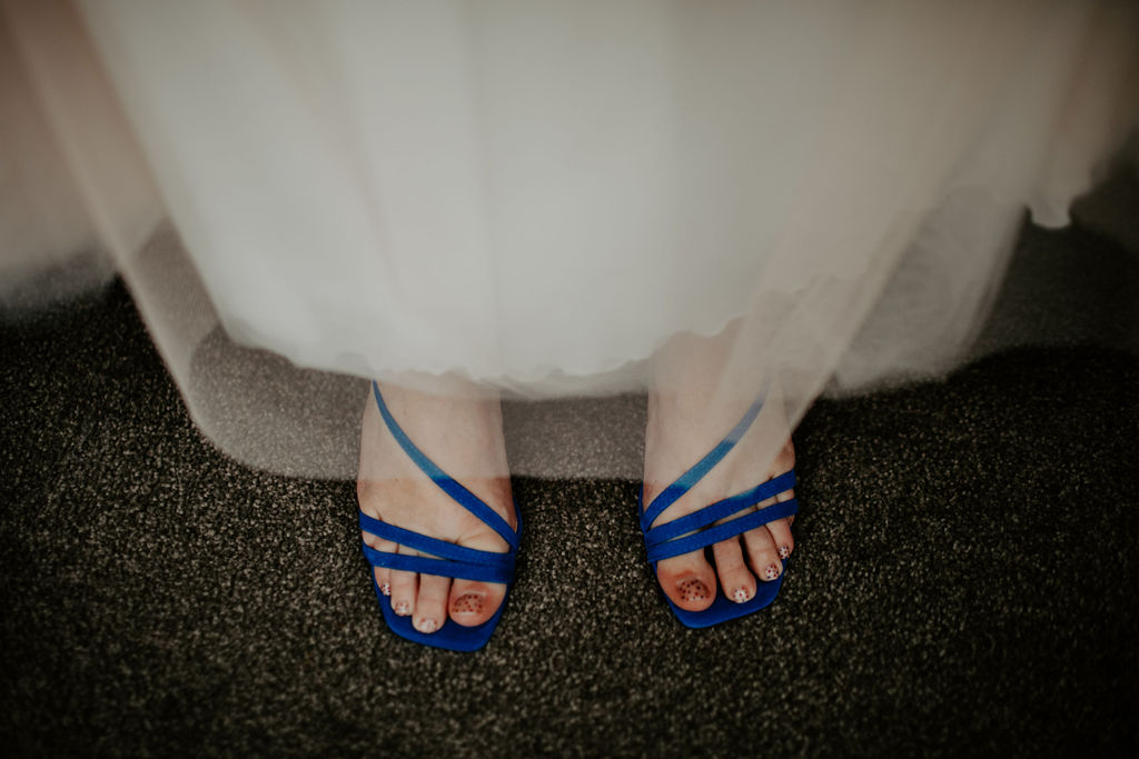 Photo looking down at bride's blue wedding shoes at Wandin Valley wedding