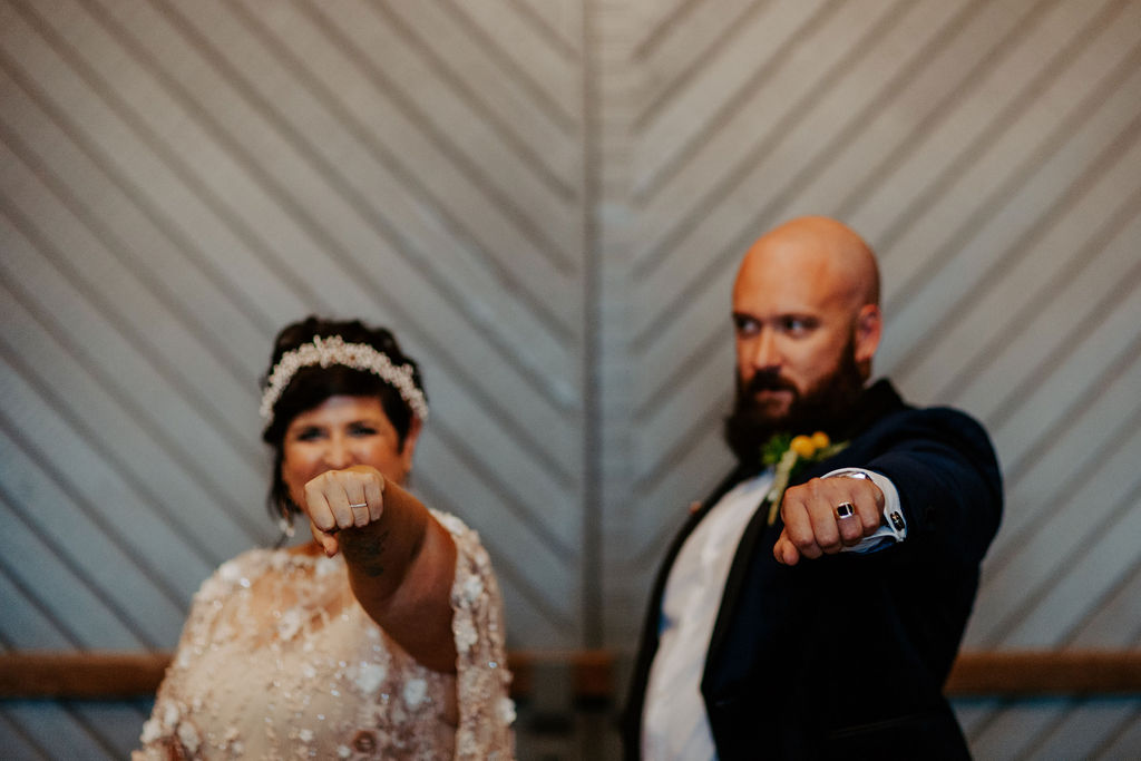 Bride and groom holding up their fists to show their wedding rings at Wandin Valley wedding
