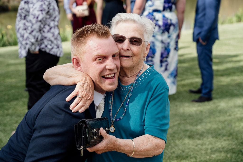 Groom hugging elderly guest at Hunter Valley Gardens wedding