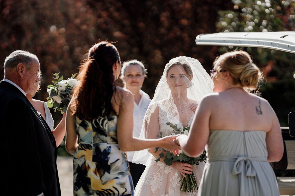 Celebrant Julie Mur talking to bride and bridesmaid at Hunter Valley Gardens wedding 