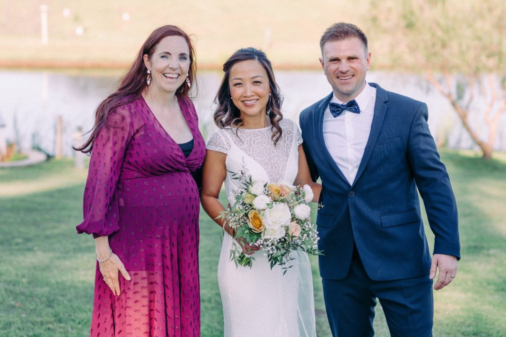 Celebrant Julie Muir, heavily pregnant posing with newlyweds after wedding at Willow Tree Estate