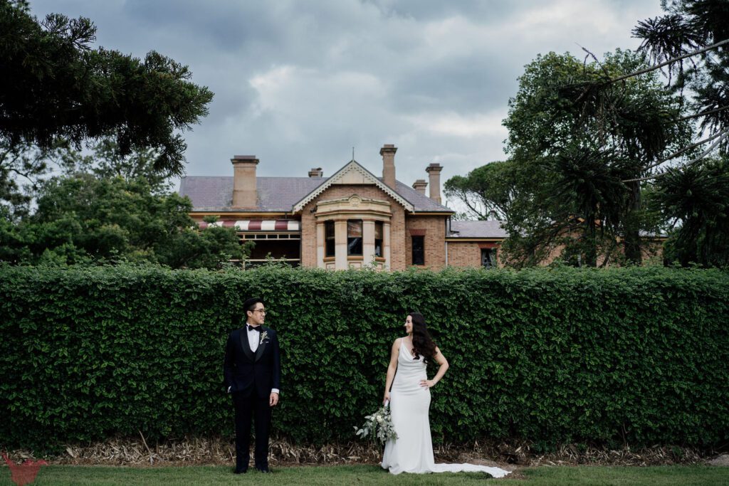 Couple staring at each other on front of a hedge at Hunter Valley Wedding Venue Anambah House