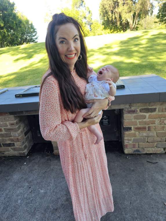 Celebrant Julie Muir holding a crying baby after Hunter Valley Baby Naming Ceremony