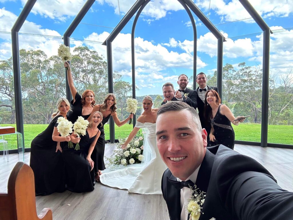 Mid ceremony group selfie with wedding party
