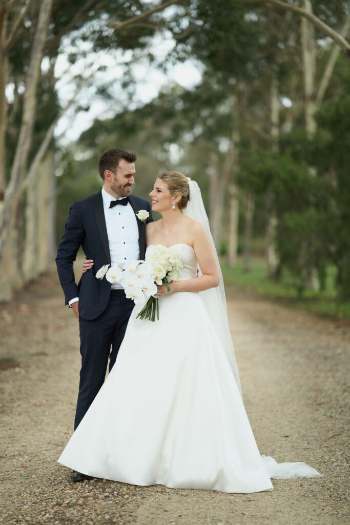 Hunter Valley Wedding Venue Peppers Creek Chapel newlyweds smiling and holding each other in the middle of a road