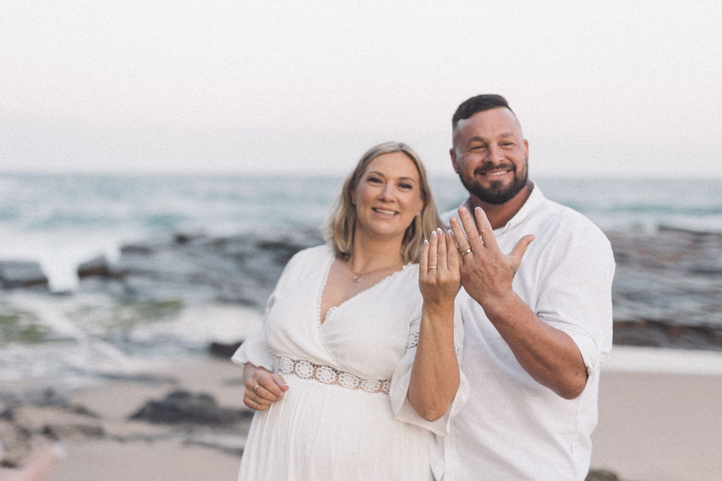 Couple holding their rings fingers to the camera during Bar Beach Elopement