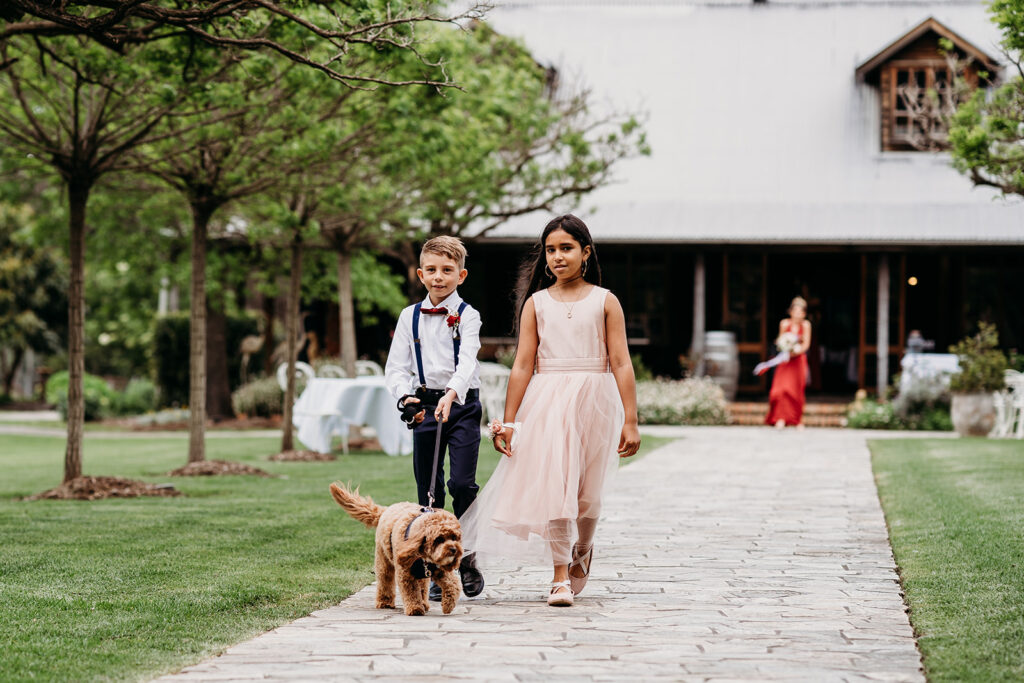 Ring bearer, flower girl, and brown dog walking down the aisle at Circa 1876 wedding venue