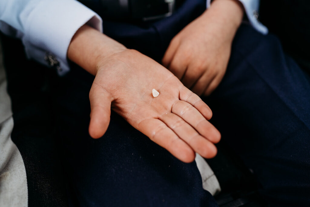 Ring bearer showing a tooth on the palm of his hand
