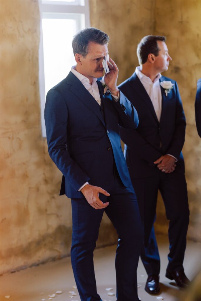 Groom wiping his tears with a white handkerchief at Peppers Creek Chapel & Barrell Room