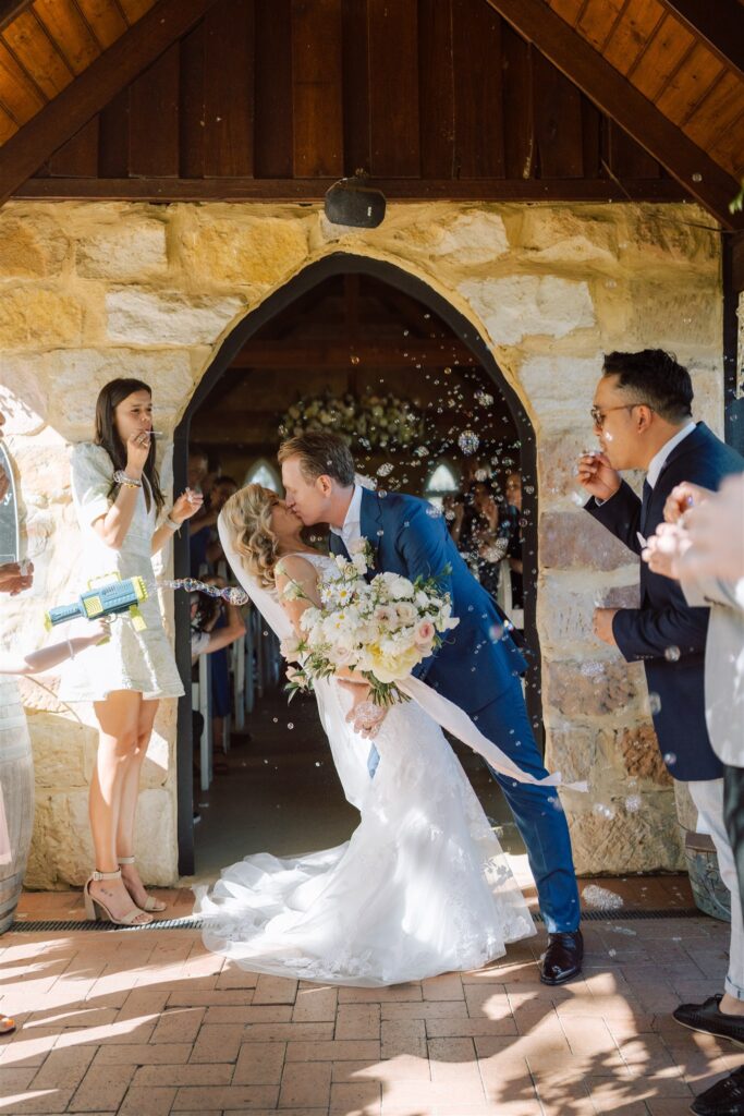 Bride and groom sharing a kiss at the entrance of Peppers Creek Chapel & Barrell Room