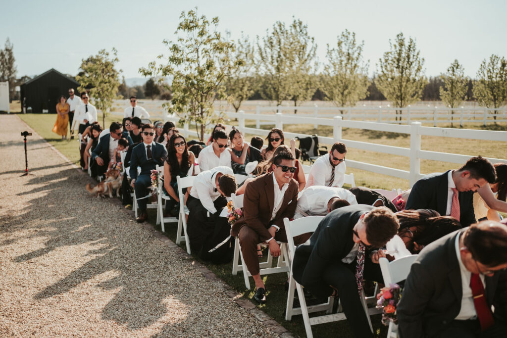 Wedding guests checking under their chairs using their hands