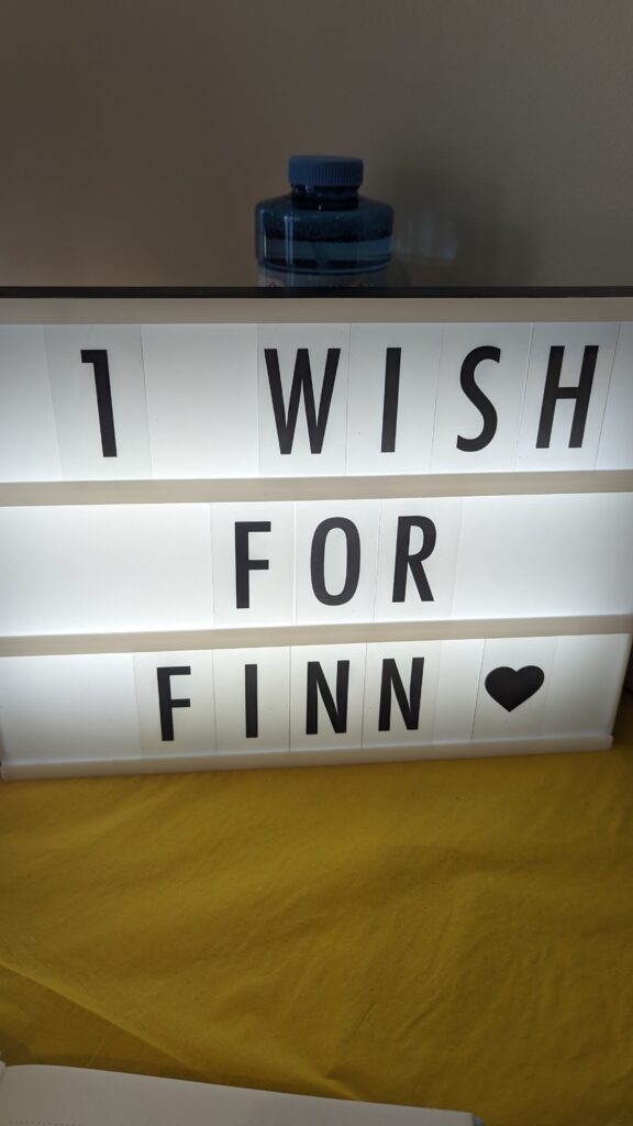 Light-up sign board saying "1 wish for Finn"
