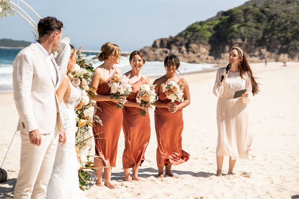 Celebrant Julie Muir talking to bridesmaids, bride, and groom mid-ceremony at Zenith Beach