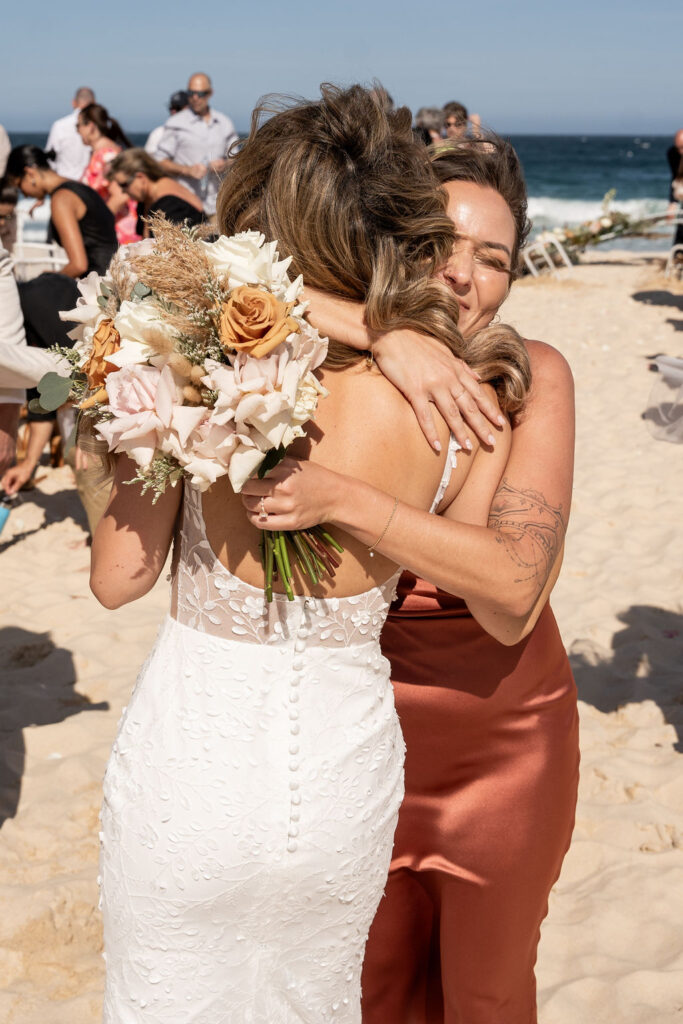 Bride hugging one of the bridesmaids at Zenith Beach