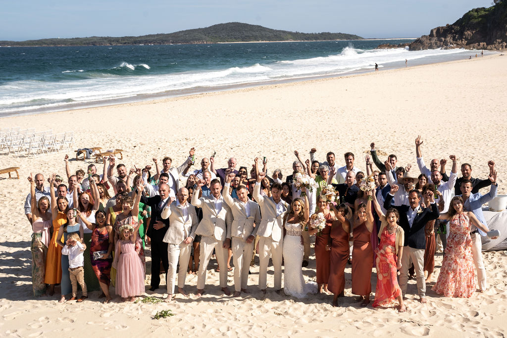 Wide shot of the newlyweds, bridal party, and the wedding guests at Zenith Beach