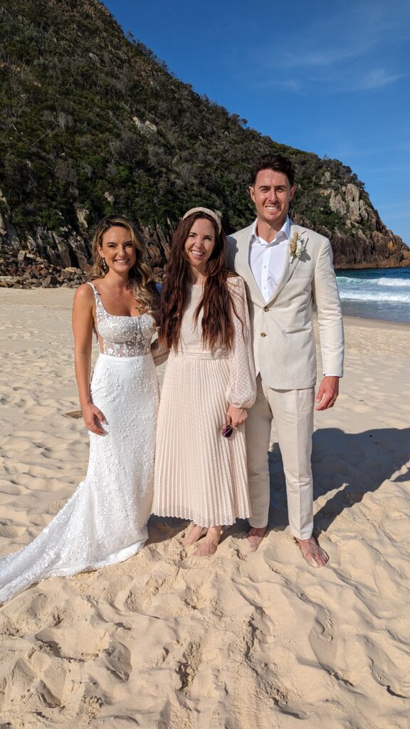 Newlyweds taking a photo with Celebrant Julie Muir at Zenith Beach