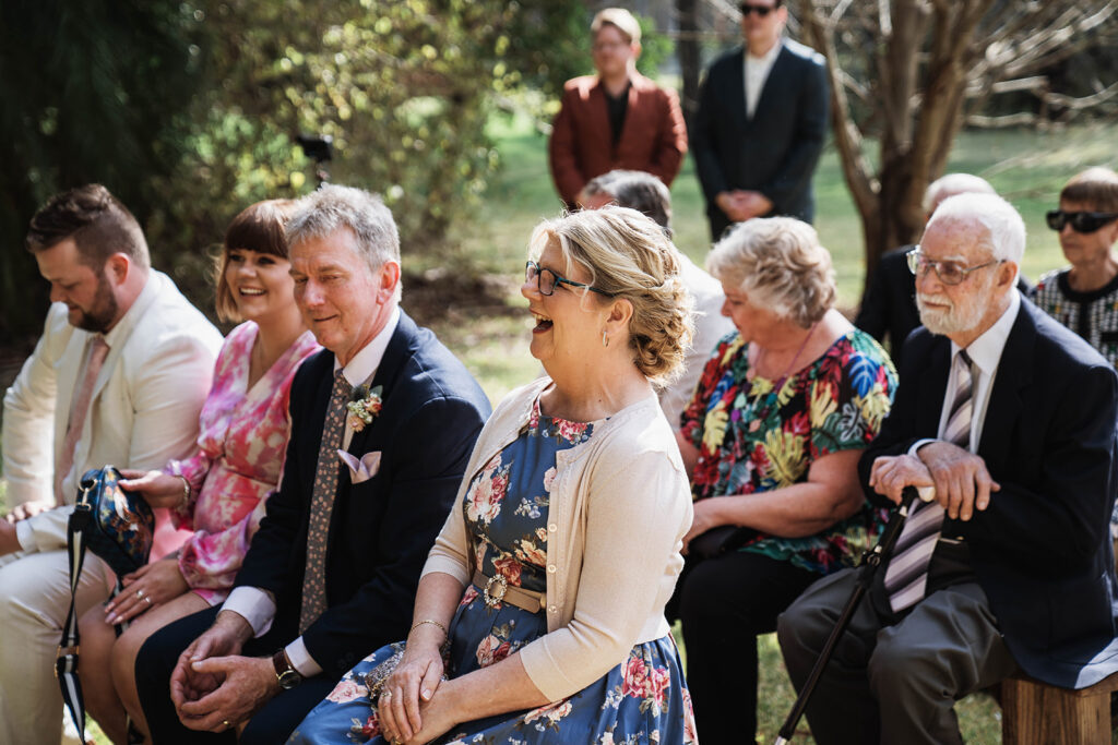 Guests laughing mid wedding ceremony at Leaves and Fishes